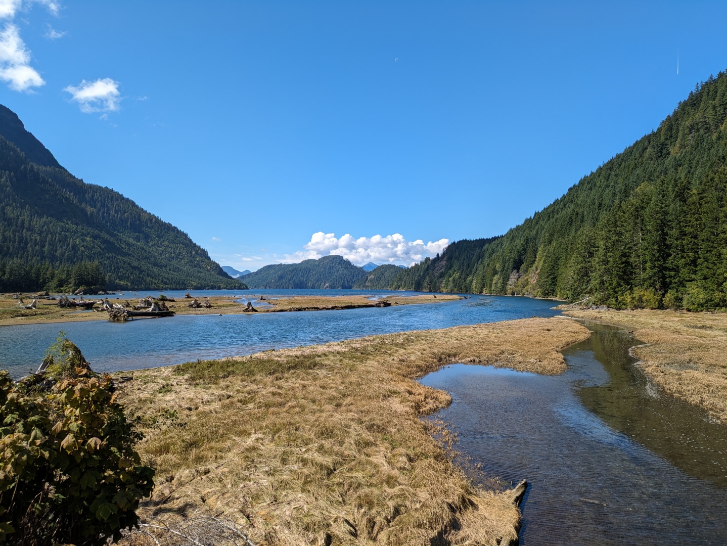 A large river flows between tree covered hillsides on the left and right.